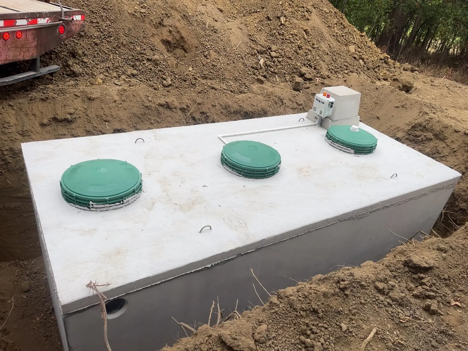 Aerobic tank with three green lids and a control box, aerobic septic system maintenance
