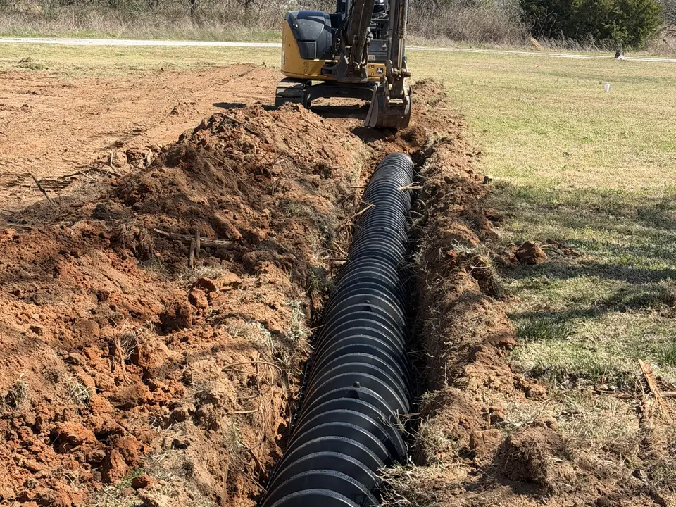 Lateral line chambers laid in a fresh trench behind a mini excavator, lateral line repair