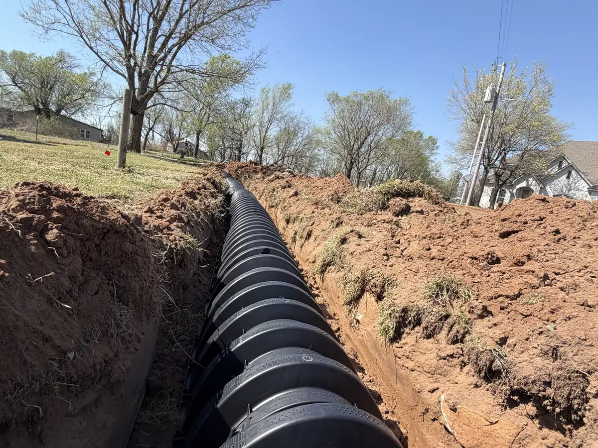Lateral line chambers running down a long trench toward nearby homes, lateral line repair