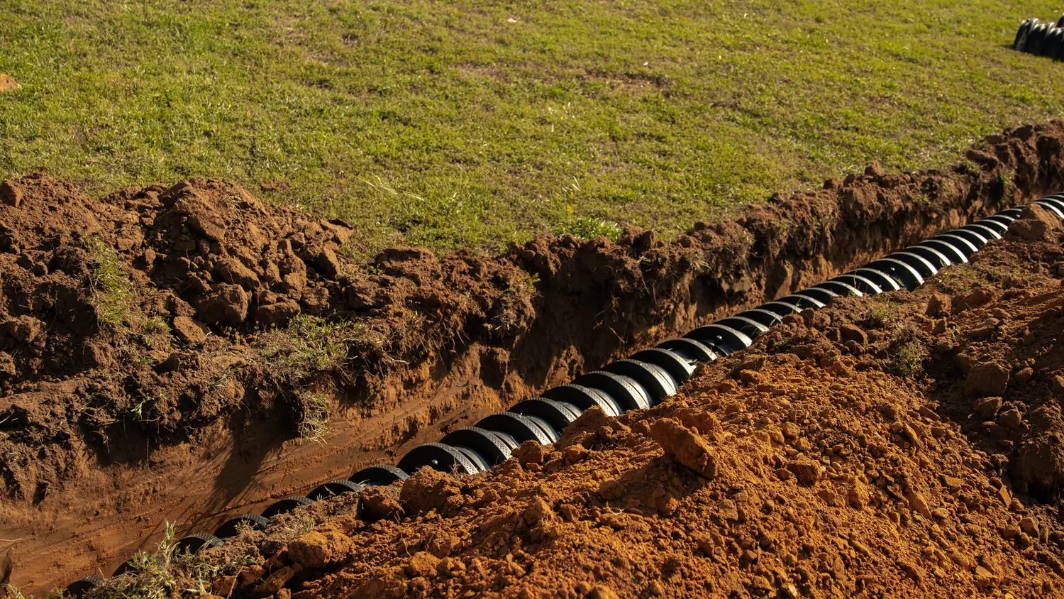 Lateral line chambers in an open trench across a lawn, septic system installation